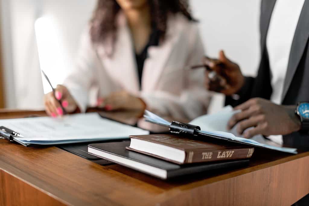 A man and woman sitting at a desk in a courtroom addressing professional liability.