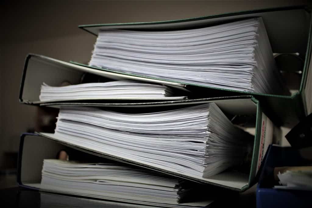 A supplemental stack of papers on a desk.