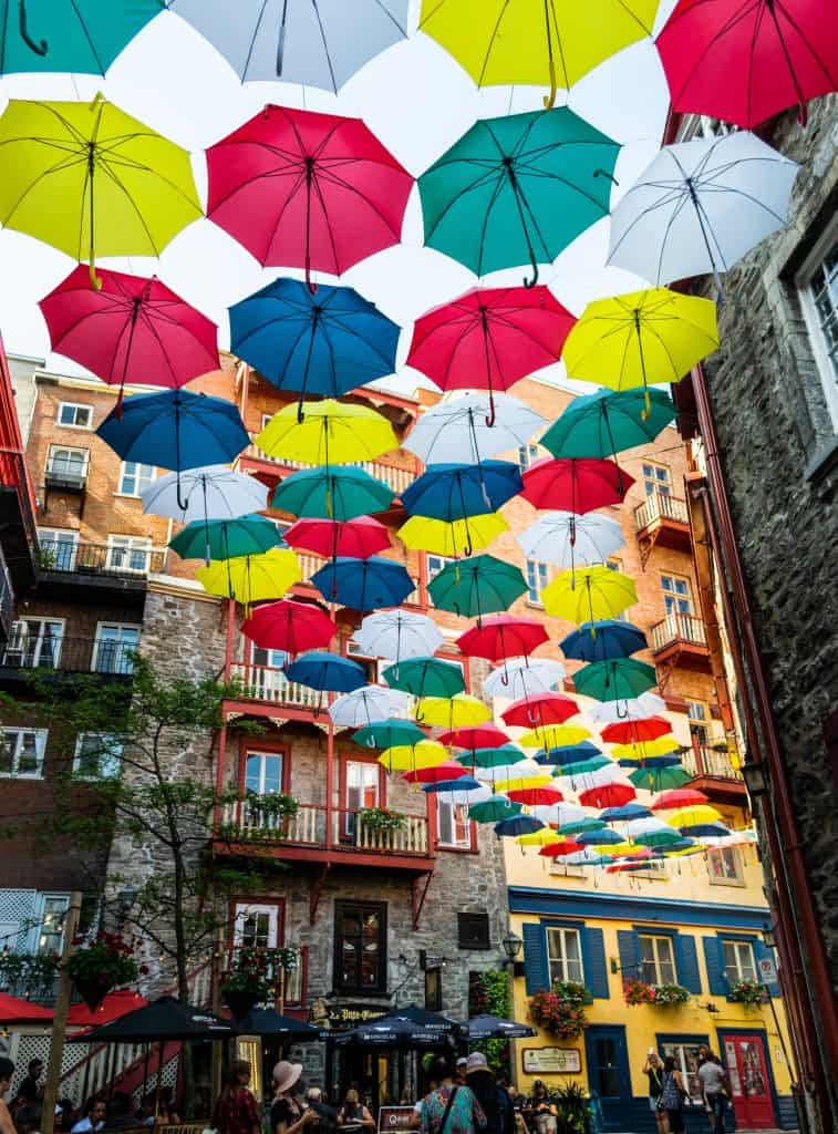 Colorful umbrellas hanging from the ceiling of a building, creating a vibrant and eye-catching display.